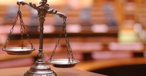 Copper Scale of Justice in a blurred courtroom