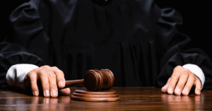 A judge sits at the table holding a wooden gavel