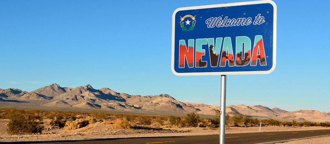 A Nevada road sign with an empty desert road in the background